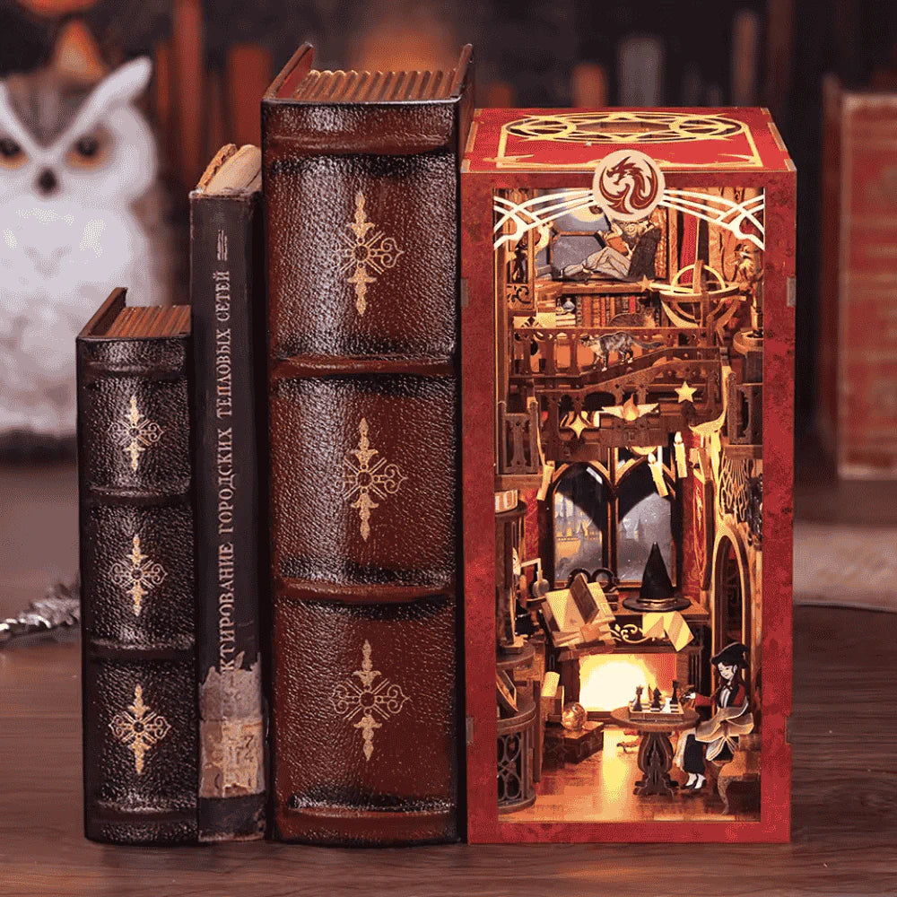 Upper floor detail of Flame Common Room book nook — miniature wizard reading a book by moonlight, full moon through crimson-curtained window, castle silhouette in background